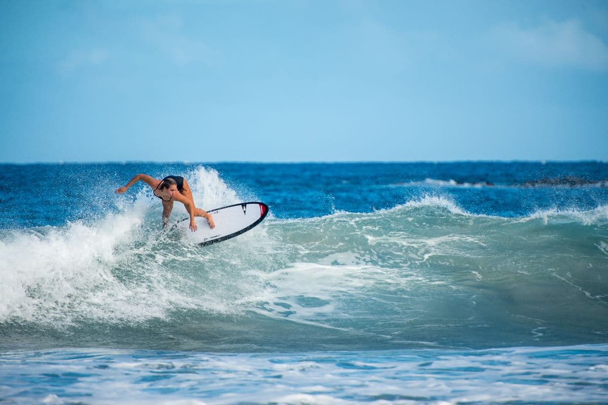 A surfer turning off the top of a blue wave