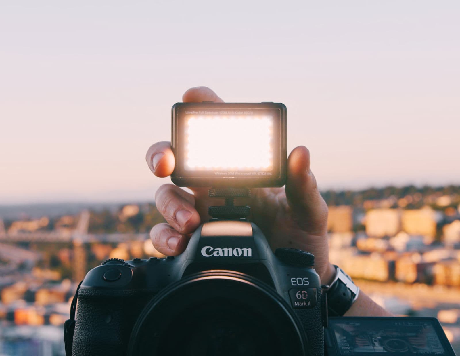 A Litra light held above a camera at golden hour